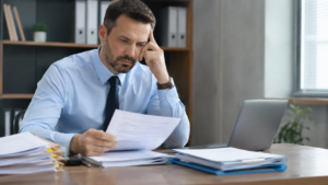 Servidor público analisando documentos funcionais e contracheques em um escritório, verificando possível atraso na promoção funcional e seus impactos na carreira e na remuneração.